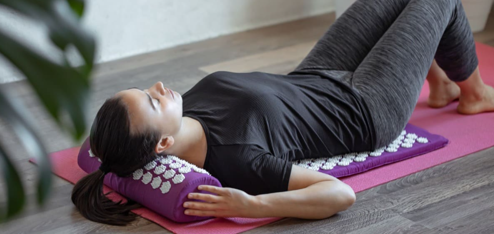Femme utilisant le tapis Zenora pour soulager le dos et la nuque